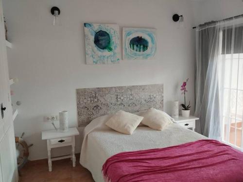 米哈斯科斯塔Coqueto apartamento en CalaHonda的一间卧室设有床、两张桌子和一扇窗户