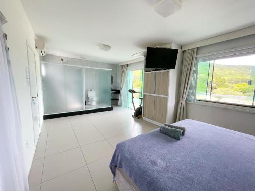 塞尔苏拉穆斯州长镇Ipê Palmas Hostel的一间卧室配有一张床,并在一间客房内配有电视。