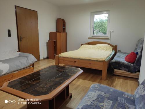 Feistritz im RosentalNice small house in beautiful Carinthia的客房设有两张床、一张桌子和一扇窗户。