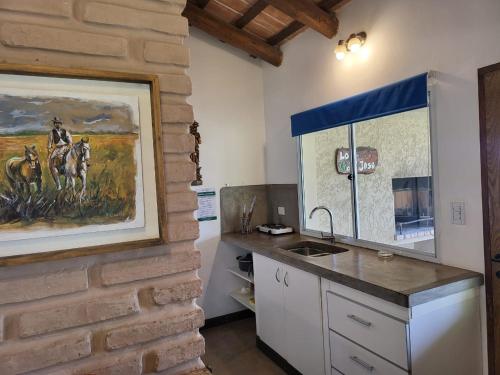 卡法亚特CASAS Viñedos de Cafayate Alquiler Temporario的厨房配有柜台,墙上挂有绘画作品