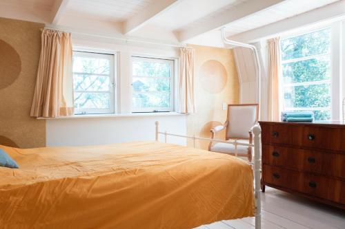 埃丹Bed and breakfast Jan的一间卧室配有一张床、梳妆台和窗户。