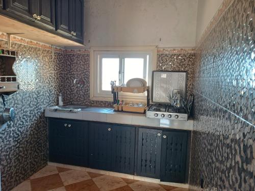 沃利迪耶Kasba的厨房配有蓝色橱柜和窗户。