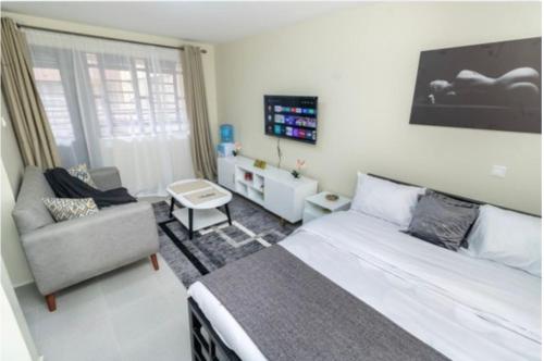 NgongCozy apartment off punda lane vet stop的一间卧室配有一张床、一张沙发和一把椅子