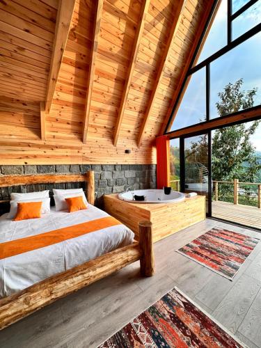 贾马里海姆森Şeni Bungalow的小木屋卧室配有1张床和1个浴缸
