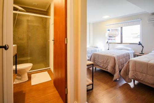 布卢梅瑙Pousada Blumenau的一间小客房,配有两张床和一间浴室