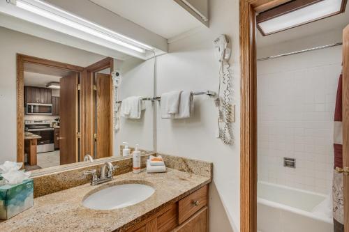 斯诺马斯村Laurelwood Condominiums 302的一间带水槽、浴缸和镜子的浴室