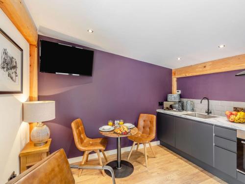 LlangadfanDaffodil - Uk40266的厨房设有紫色墙壁和桌椅