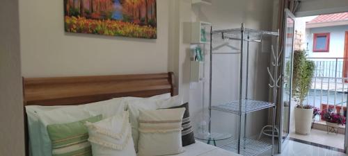 库尼亚Hospedagem Quarto Chic centro Cunha的一间卧室配有带白色枕头的床
