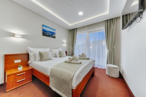 多布拉沃达Hotel BH的一间卧室设有一张大床和一个窗户。