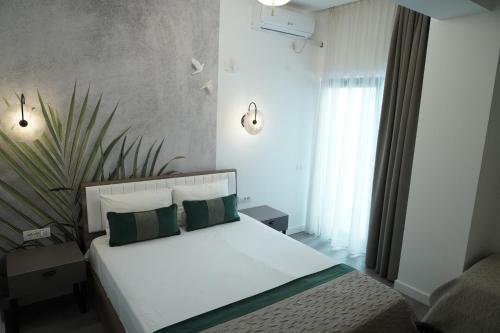 艾福雷诺德Denis Boutique的卧室配有带绿色枕头的白色床