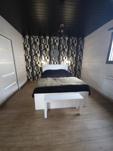Saint-Vigor-le-GrandLe Chalet de St Vigor的卧室配有白色的床和黑色墙壁