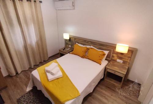 科维良Casa da Floresta的一间卧室配有一张带黄色枕头的大床