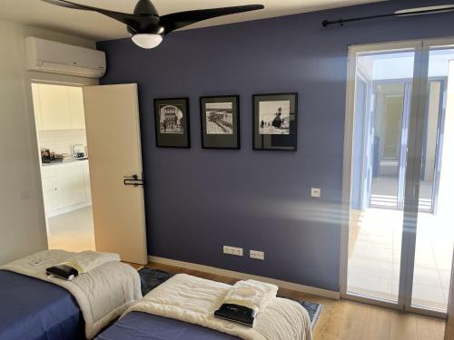 塔维拉Picasso Apartament的一间卧室设有蓝墙和吊扇