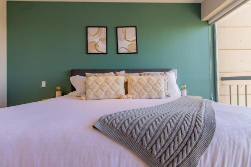 墨西哥城Capitalia - Apartments - Santa Fe的卧室配有一张白色大床,墙上挂有两张照片