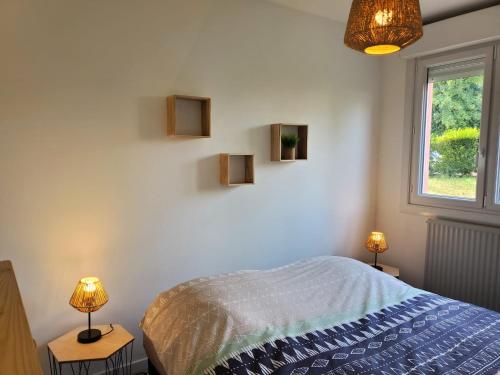 梅斯Sweet appartement entier Metz Sablon Gare 75 m2的一间卧室配有一张床、两盏灯和一个窗户。