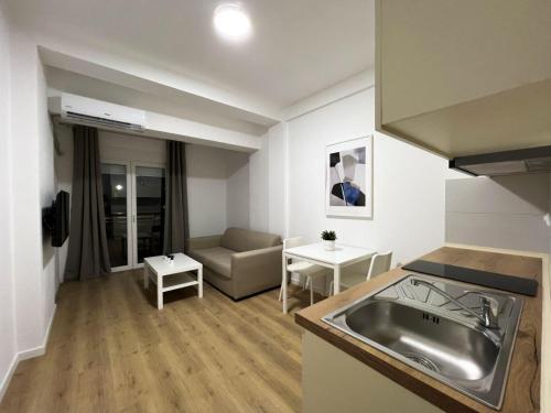 盖夫盖利亚Lumi Apartments的厨房以及带水槽和沙发的客厅。