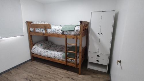 乌斯怀亚Departamento Yekamush 3 Ushuaia的客房设有两张双层床和橱柜。
