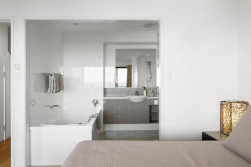 汉密尔顿岛Shorelines 27 Ocean View Buggy Transfers BBQ的白色的浴室设有浴缸和水槽。