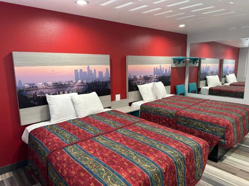 洛杉矶Sahara Inn - Los Angeles的酒店客房,设有两张带红色墙壁的床