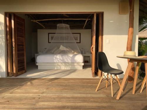 TlachicónVilla Arena Puerto Escondido Beach Front的一间卧室配有一张床、一把椅子和一张桌子