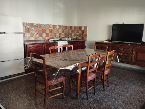 萨尔塔Departamentos Temporarios Salta的一间带桌椅和电视的用餐室