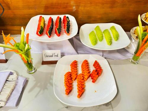 东枝LOI LOUNG HOTEL的桌上的三盘胡萝卜和蔬菜