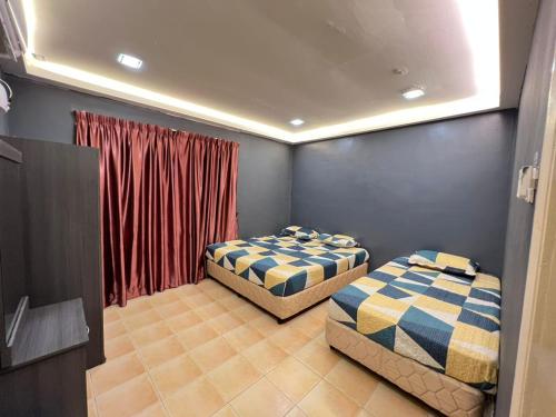 马六甲BESLA HOMESTAY LOT986 at A'Famosa Resorts Melaka Villa, 5rooms, private pool, BBQ, KARAOKE with surcharge的配有红色窗帘的客房内的两张床