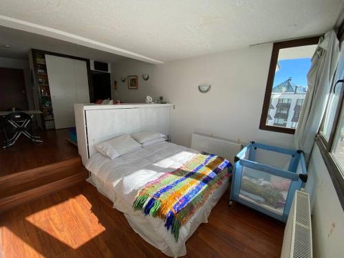 圣地亚哥El Colorado, Farellones.的一间卧室配有一张带彩色毯子的床
