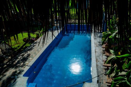 Cái RăngAnn Village的一座拥有蓝色海水和棕榈树的游泳池