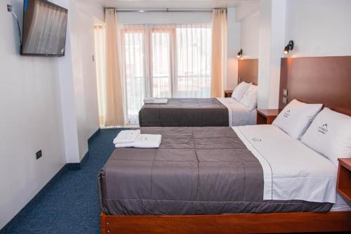 瓦拉斯Hotel Turístico Everest的酒店客房设有两张床和电视。