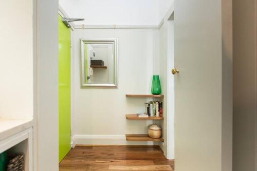 悉尼Tranquil 1 Bedroom Apartment - Rushcutters Bay Self-Catering的走廊上设有绿色和白色的墙壁和镜子