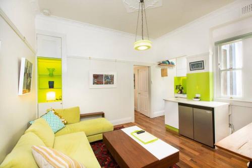 悉尼Tranquil 1 Bedroom Apartment - Rushcutters Bay Self-Catering的客厅配有黄色的沙发和桌子