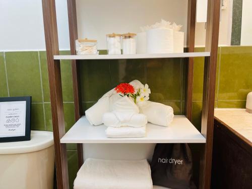 珀拉什奇亚Alux House的浴室内带毛巾和鲜花的架子