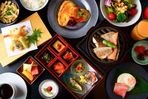 廿日市Grandvrio Hotel Miyajima Wakura - ROUTE INN HOTELS -的一张桌子上放着许多盘子的食物