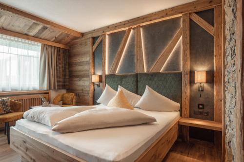 菲根客乐福酒店的一间卧室设有一张带木墙的大床