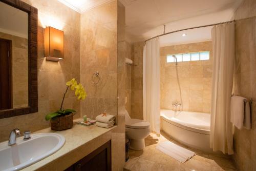 库塔瑞萨塔巴厘岛假日及温泉酒店的带浴缸、盥洗盆和卫生间的浴室
