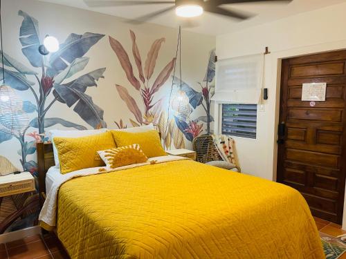 珀拉什奇亚Alux House的一间卧室配有一张黄色的床,并拥有热带壁纸