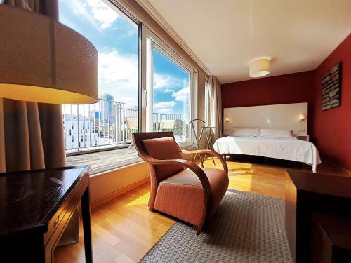 布鲁塞尔MAS Aparthotel EU的卧室配有床、椅子和窗户。