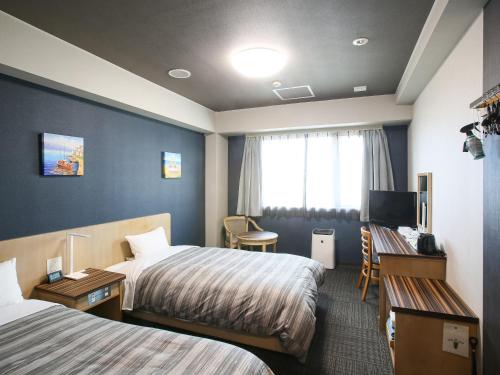 石垣岛石垣岛格兰蒂亚路线酒店的酒店客房配有两张床和一张书桌