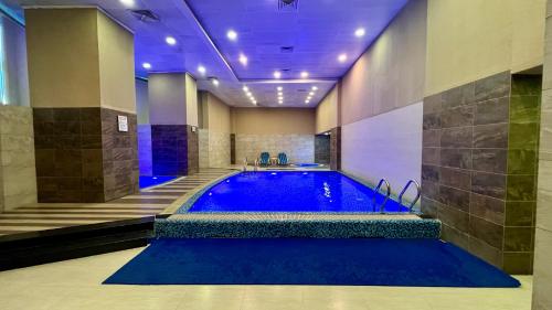 伊斯兰堡Centaurus Apartment City View Three Beds的一座带蓝色浴缸的大楼内的大型游泳池