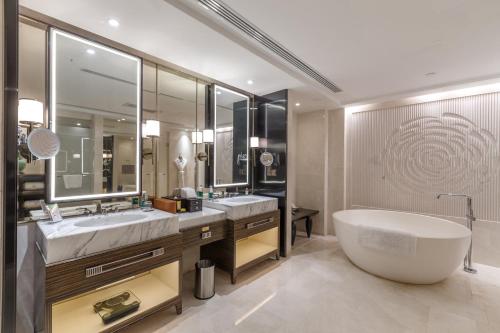 南京南京圣和府邸豪华精选酒店的一间带大浴缸和大镜子的浴室