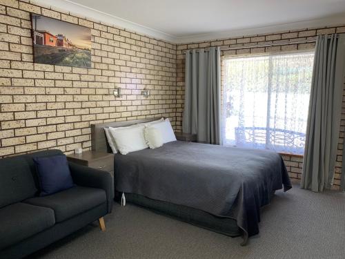 考拉考拉佳洁士汽车旅馆 的一间卧室配有一张床、一张沙发和一个窗口