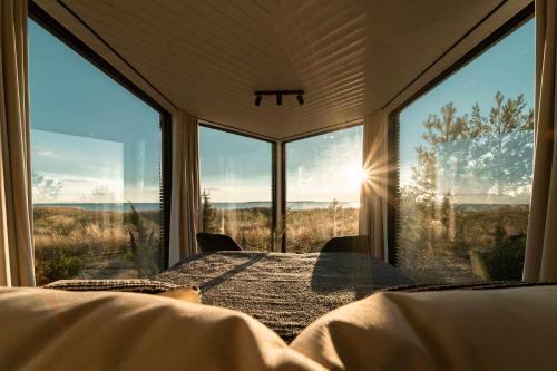 Exclusive off-grid tiny home at the beach - Kenshó的一间卧室设有一张床和大窗户