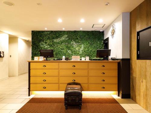 福冈里格纳福雷斯塔酒店的卧室配有梳妆台,墙上挂着一幅大画