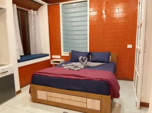 维特利Nostalgia Homestay的一间卧室配有一张带紫色床单的床和窗户。