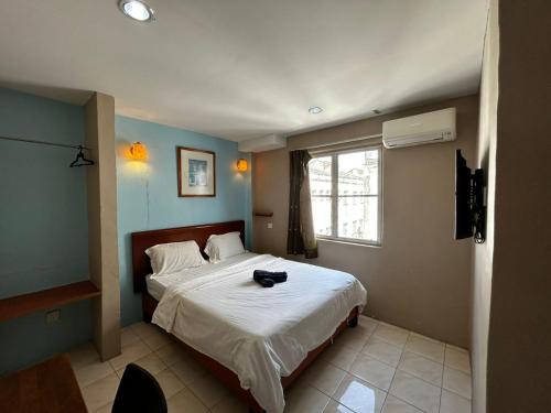 马六甲Hotel Harbour Stay的一间卧室,配有一张床,上面有帽子