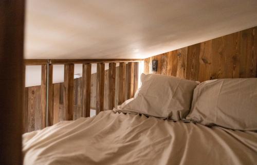 莫尔济讷IMMODREAMS - La Cabane的一张带白色床单和枕头的床