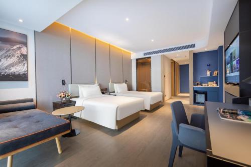 高平晋城高平高铁东站亚朵酒店的酒店客房,设有两张床和一张沙发