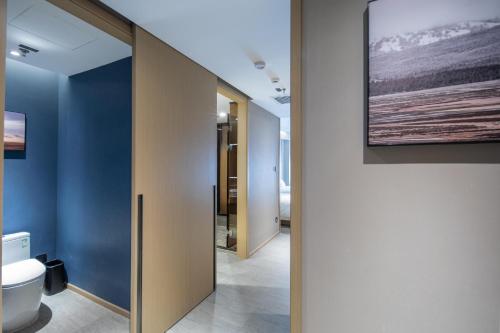 高平晋城高平高铁东站亚朵酒店的一间带卫生间的浴室和墙上的绘画