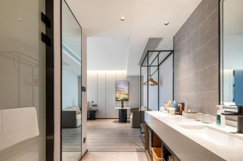 台州台州路桥亚朵酒店的一间带两个盥洗盆的浴室和一间客厅。